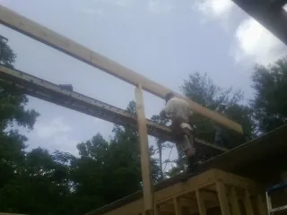 Carpenter setting a ridge beam over a new addition frame — Ice Dam Removal by Roofing Brothers in Walsenburg