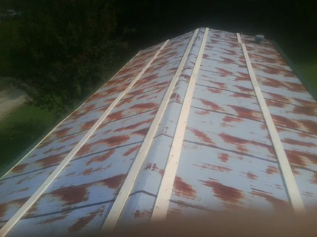 Rusted metal roof panels with new wood purlins before replacement — Storm Damage Roof Repair in Walsenburg by Roofing Brothers