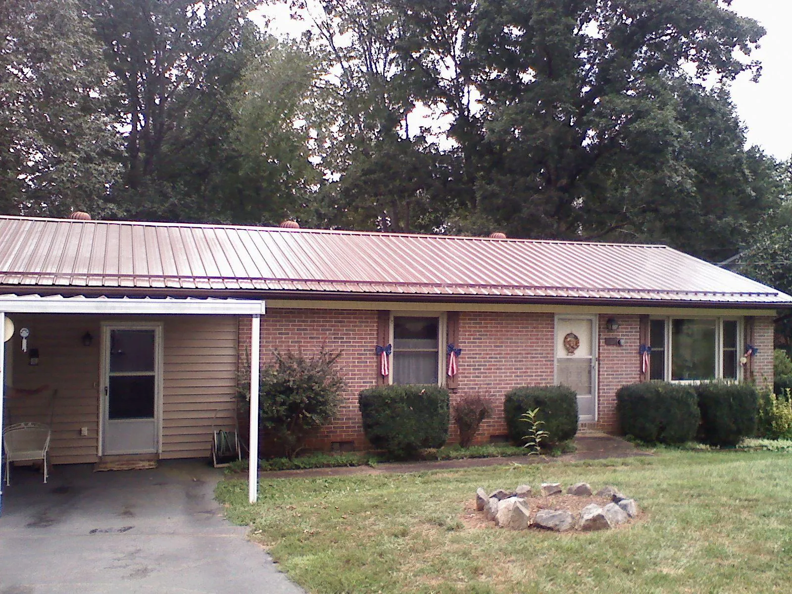 Bronze metal roof and carport on a brick ranch home — Roof Repair work by our crew in Walsenburg